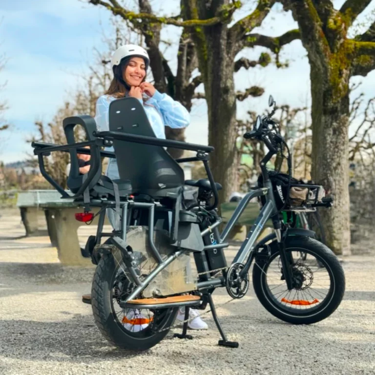 en premier plan un velo electrique longtail avec la propriétaire en fond